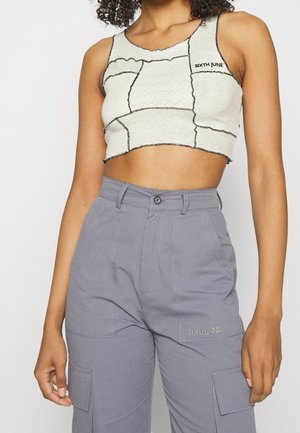 Szary crop top z czarnymi przeszyciami i logo "SIXTH JUNE", w zestawie z szarymi spodniami cargo z przednimi kieszeniami i subtelną fakturą.