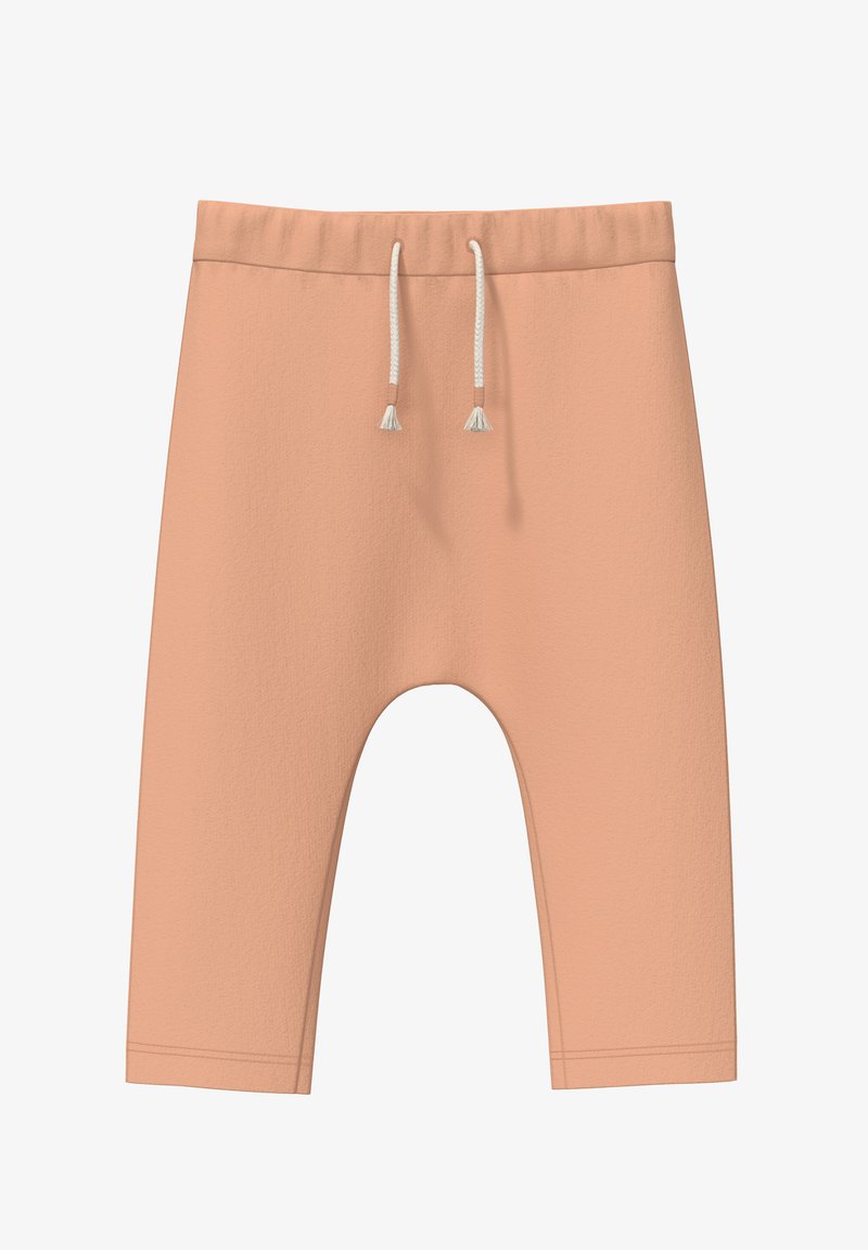 Shorts de color durazno con una textura suave, cinturilla elástica y cordón con borlas. Presentan un corte suelto y una longitud a media pantorrilla.