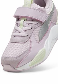 Fioletowy but sportowy wykonany z siateczki i zamszu, z teksturowaną podeszwą oraz rzepem. Akcenty w kolorze srebrnym i jasnej zieleni.