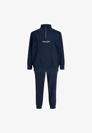 Tumed sinine treeningülikond, millel on lukuga kaelus, elastsed mansetid ja vöökoht. Ülaserval on rinnal prinditud valge "Jack & Jones" logo.