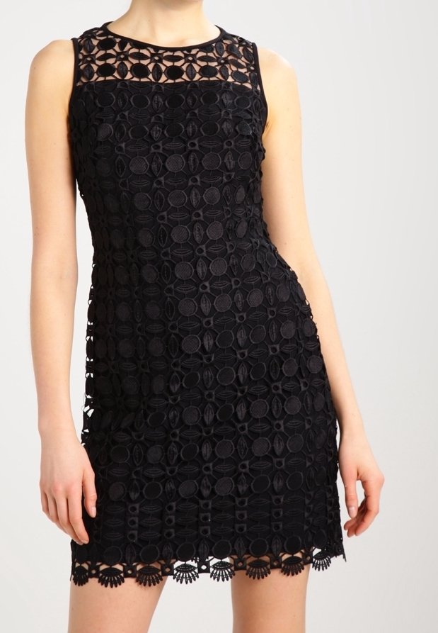 Svart ärmlös klänning med intrikata cirkulära spetsmönster, en fast halsringning och vågig nederkant. Tillverkad av texturerat tyg.