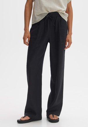 Black, wide-leg pants made of lightweight fabric with an elastic waistband and drawstring, providing a relaxed fit and smooth texture.