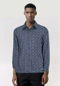 Camicia a maniche lunghe di colore blu navy con un piccolo motivo floreale. Realizzata in tessuto leggero, presenta un colletto a punta e chiusura con bottoni.