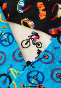 Chaussettes colorées avec des arrière-plans bleu, noir et crème, ornées de motifs de bicyclettes, de roues et de lunettes de soleil colorées. Matière en tricot texturé.