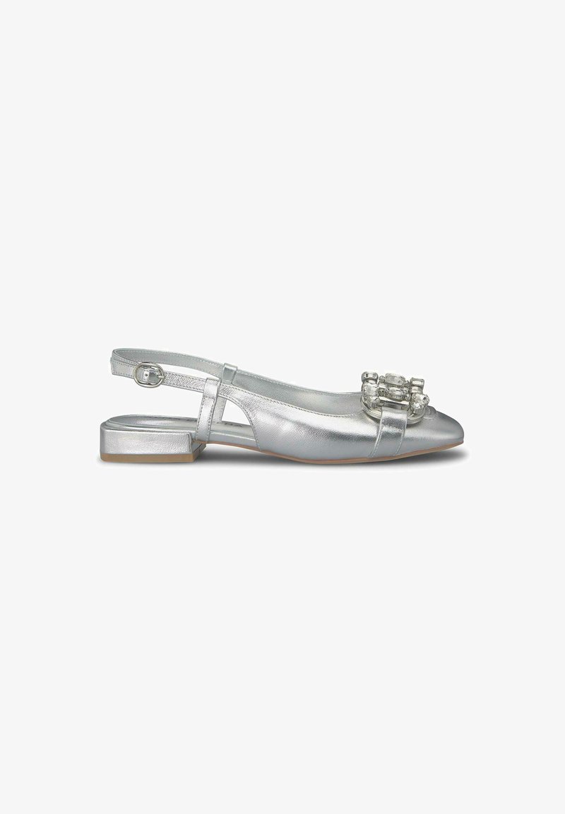 Zapato slingback plateado con un tacón bajo, que presenta un acabado metálico suave y acentos decorativos de gemas transparentes en la punta.