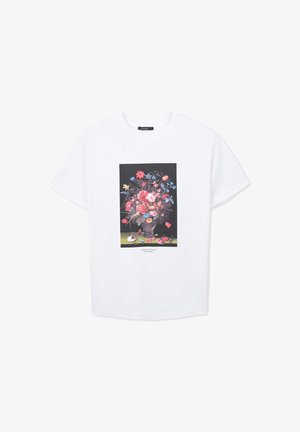 T-shirt blanc à manches courtes avec une peinture de bouquet de fleurs coloré sur un fond sombre imprimée sur le devant.