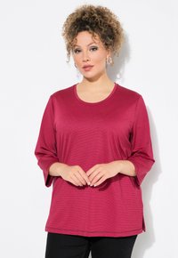 Maglia bordeaux a maniche lunghe con scollatura rotonda e spacchi laterali. Realizzata in un tessuto morbido con una leggera trama e spalle scese.