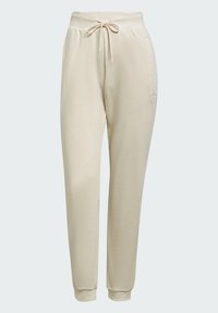 Pantaloni jogger in fleece beige con vita elasticizzata, coulisse, tasche laterali e polsini a costine. Design semplice con una texture morbida.