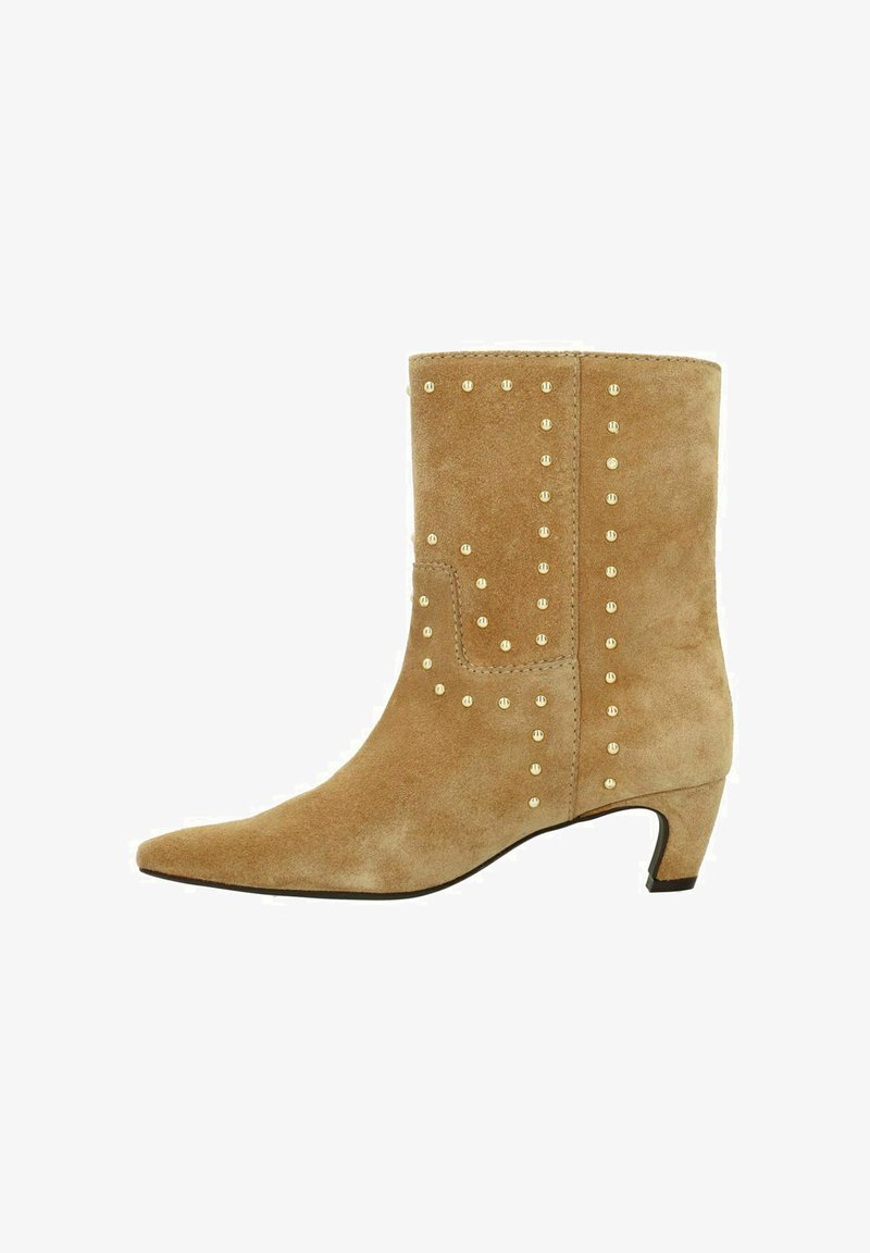 Bottines en suede beige avec un talon bas courbé et des clous dorés le long des côtés et du bord supérieur.