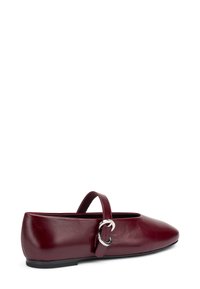 Bailarinas de cuero burdeos con punta afilada, correa ajustable y detalle de hebilla plateada. Textura suave con un perfil bajo.