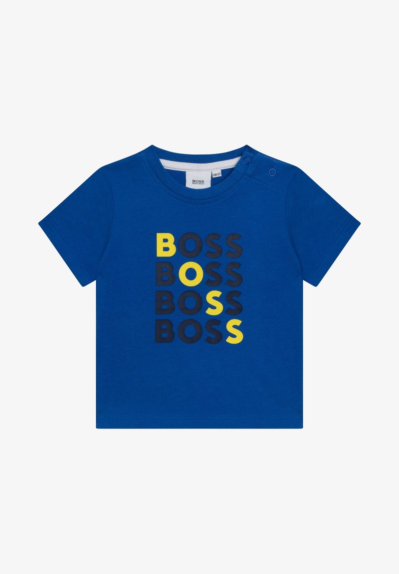 Camiseta de algodón azul con texto impreso "BOSS" en amarillo y negro, con cuello redondo y dos botones en el hombro para ponérsela con facilidad.