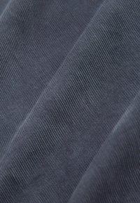 Tessuto blu scuro con una superficie texture caratterizzata da sottili motivi a righe. Texture morbida, intrecciata strettamente, con una leggera lucentezza in alcune aree.