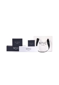 Cinque scatole per imballaggio di varie dimensioni, due in navy con il testo in rilievo "MYC PARIS", una bianca con lo stesso testo e una borsa da shopping bianca.