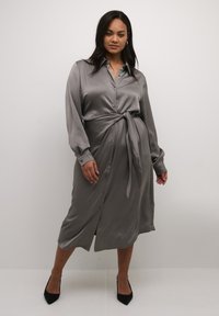 Grau satin Kleid mit langen Ärmeln, Knopfleiste und einer Bindegürtel-Detail. Verfügt über eine glatte Textur und eine mittellange Silhouette.