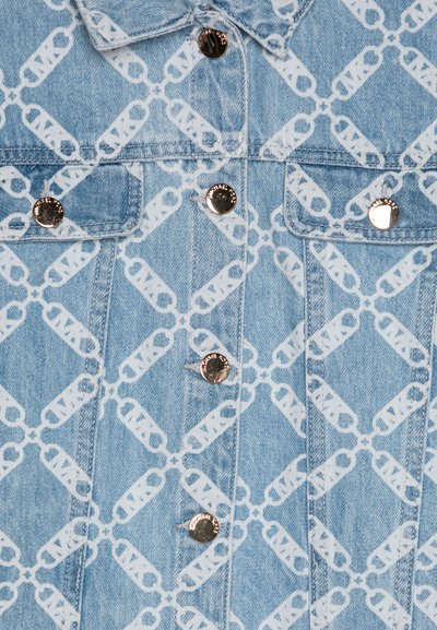 Veste en denim de couleur bleu clair avec un motif répétitif d'épingles de sureté blanches. Des boutons-pression argentés embellissent le devant et les poches.