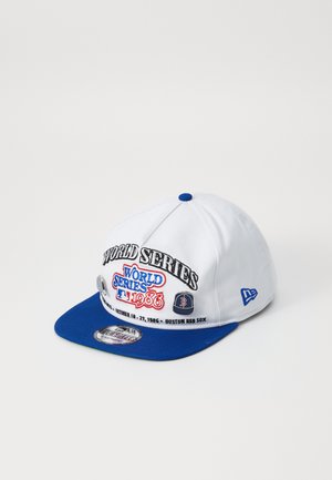 Casquette de baseball blanche avec une visière bleue, portant une broderie "WORLD SERIES 1986" et des détails des Boston Red Sox. Fabriquée en tissu avec un design structuré.