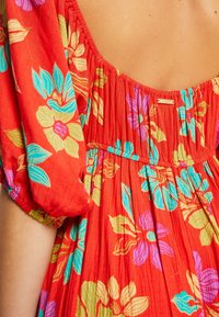 Rotes Kleider aus Stoff mit bunten Blumenmustern in Blau, Grün und Lila. Mit Puffärmeln und einem gerafften Rückendesign.