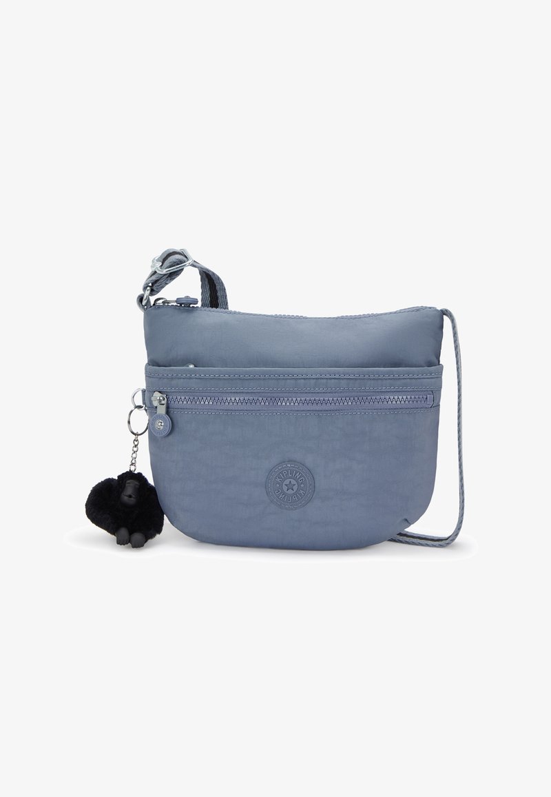 Světle modrá nylonová crossbody taška se zipovými přihrádkami, nastavitelným popruhem a připojeným černým klíčenkou ve tvaru gorily. Kulatý logo detail na přední straně.