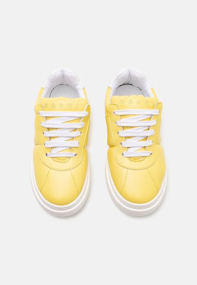 Gula lädersneakers med vita snörning, rund tå och vit gummisula. Har "MARNI" präglat på tungan. Slät textur.