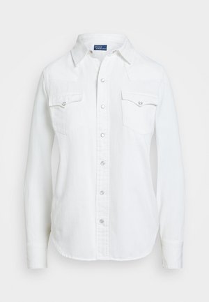 Valkoinen pitkähihainen nappilistallinen paita, jossa kaksi rintataskua ja kaulus, edessä nepparit.