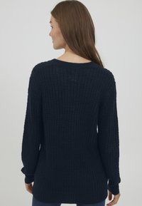Pullover in maglia navy con texture, dal fit ampio, maniche oversize e collo rotondo. Presenta polsini e orlo ribattuti.