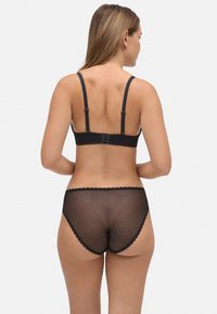 Conjunto de lencería negra que incluye un sujetador con detalles de encaje y tirantes ajustables, y una braguita de red transparente con borde en forma de ondas.