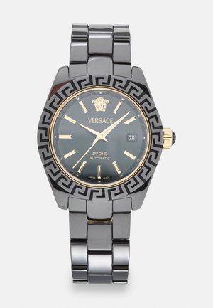 Versace DV One avtomatska ura s črnim ohišjem iz nerjavnega jekla in zapestnico, temno zelenim številčnikom, zlatimi poudarki in grškim ključem na bezelju.
