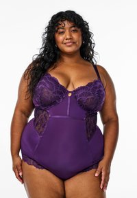 Paarse bodysuit met kantaccenten op de buste en zijkanten, met een gladde textuur en een sleutelgatdetail in het midden.