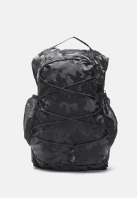Zaino nero con motivo camouflage, dotato di tasche laterali in rete, una chiusura a zip frontale e dettagli con cordini elastici sulla parte anteriore. Materiale in nylon testurizzato.
