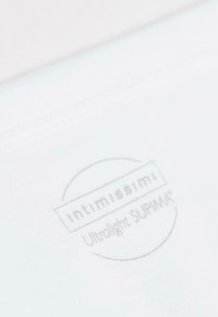 Biała tkanina o miękkiej fakturze z nadrukowanym logo "intimissimi Ultralight SUPIMA®" w jasnoszarym kolorze. Krawędź tkaniny jest bezszwowa.