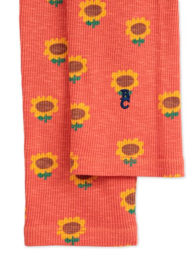 Coral ribbed socks featuring a sunflower print in yellow and brown, with green accents. Includes a small blue embroidered logo.
