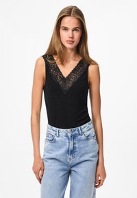 Black sleeveless bodysuit with lace detailing along the V-neckline, paired with light blue high-waisted jeans. Smooth texture and fitted shape.