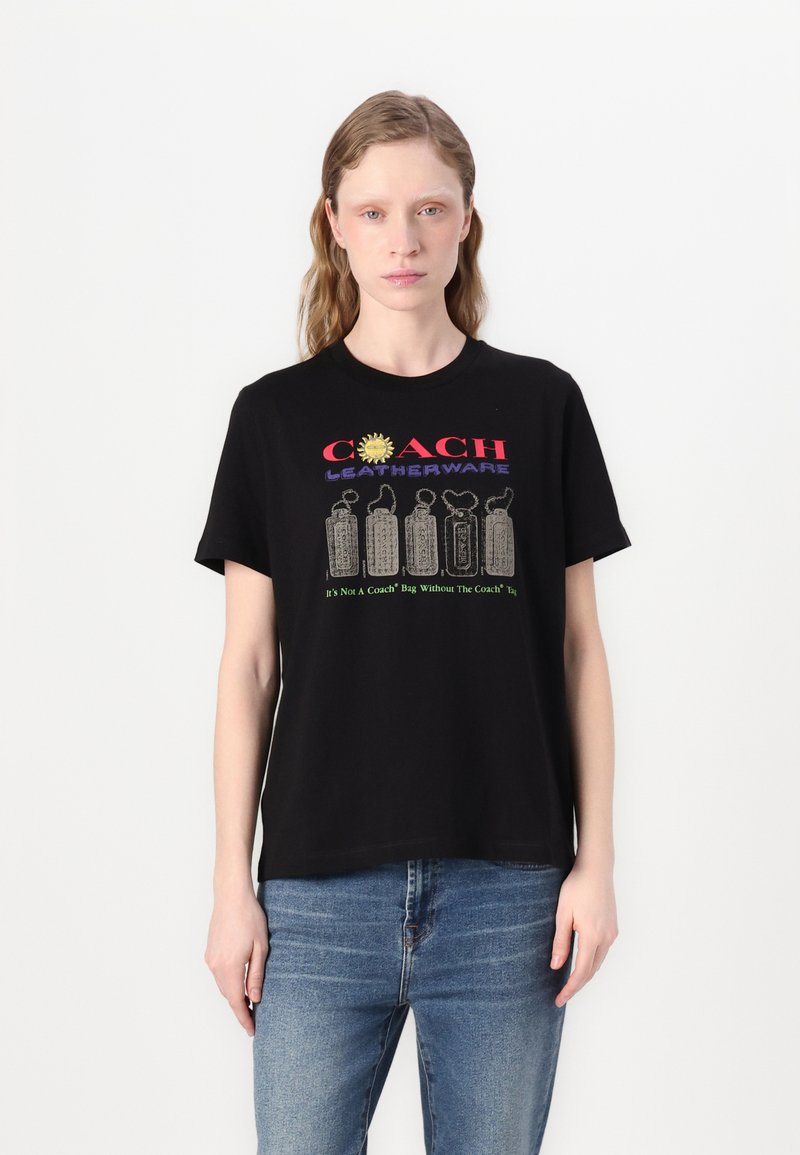 Camiseta de algodón negra con texto "COACH LEATHERWARE" y gráficos coloridos en la parte frontal, corte relajado, mangas cortas.