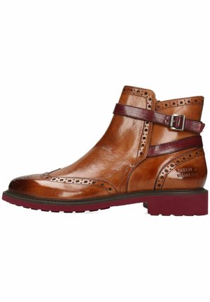 Bottine en cuir marron avec des détails de brogue, sangle bordeaux avec boucle et semelle texturée. Fini poli et perforations décoratives.