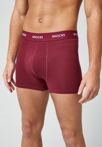 Boxer shorts burdeos hechos de tela suave. Presentan un ajuste ceñido, costuras suaves y una cinturilla elástica con logotipo.