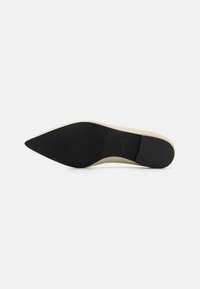 Boty s špičatou špičkou a krémovým svrškem, s černou gumovou podrážkou. Hladký povrch svršku, s mírným leskem. Minimalistický design.