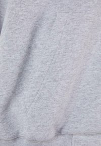 Grå sweatshirtsstof med en blød tekstur, har en kenguru-lomme og en ribbet kant, og viser et subtilt meleret mønster.