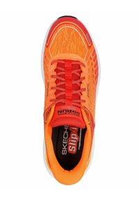 Scarpa sportiva arancione brillante con tomaia in rete, linguetta imbottita e lacci elastici. Presenta una suola bianca con dettagli rossi e branding.