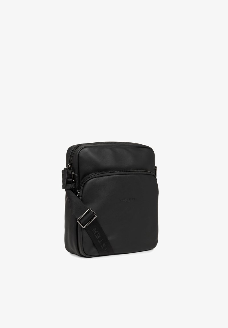 Borsa a tracolla in pelle nera con scomparto principale con cerniera, tasca frontale, tracolla regolabile e dettaglio logo sobrio. Texture liscia.