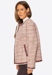 Teksturowana kurtka w pastelowych kolorach z kratkowanym wzorem, brązowymi skórzanymi akcentami, złotymi guzikami i okrągłym kołnierzem.