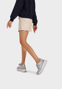 Scarpe sportive grigie con sovrapposizioni in rete e sintetico, dotate di un collare imbottito, chiusura con lacci e una suola intermedia bianca.