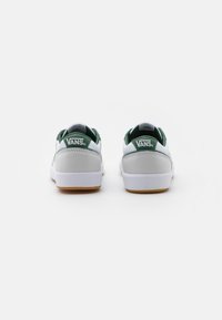 Vans sportbačiai su baltu odiniu viršumi ir žaliais akcentais, guminis padas ir logotipas kulne. Minimalistinis dizainas su paminkštintu apykakle.