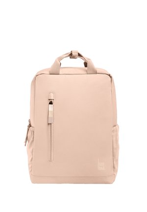 Beige rektangulær rygsæk med øverste håndtag, front vertical lynlåslomme, sidelommer og diskret "GOT BAG" logo nederst til højre.