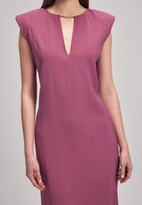 Robe ajustée en tissu mauve, présentant un décolleté en V profond avec des éléments dorés, des manches courtes et des coutures verticales pour une silhouette cintrée.