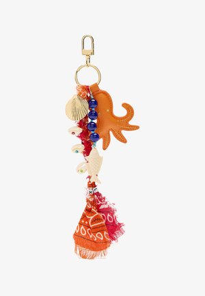 Breloczek o kształcie ośmiornicy wykonany z pomarańczowej skóry, ozdobiony niebieskimi koralikami, muszlami i frędzlami z tkaniny w kolorach czerwonym i pomarańczowym, z misternymi wzorami i teksturami.