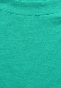 Türkiser Baumwollstoff mit glatter Textur, der ein einfaches, einfarbiges Design und einen runden Ausschnitt aufweist, mit gleichmäßigen Nähten.