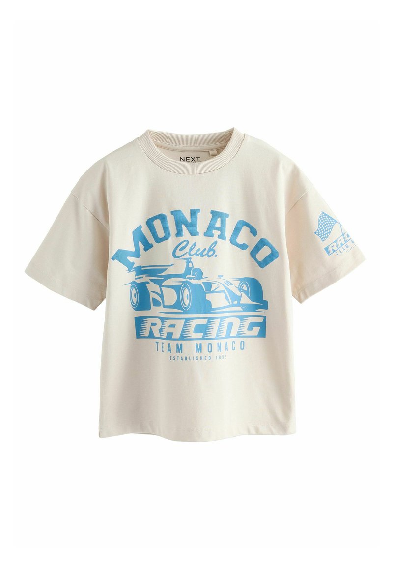 Krémové tričko s grafikou ve světle modrém závodním stylu. Obsahuje texty "MONACO Club" a "RACING", krátké rukávy a kulatý výstřih.