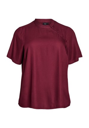 Blouse bordeaux à manches courtes avec un col rond, texture lisse et détails de boutons sur l'épaule. Coupe ajustée et tissu doux.