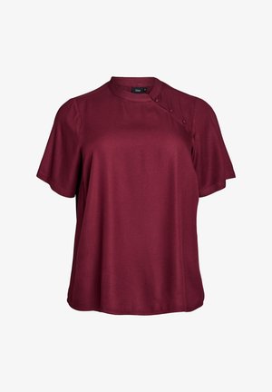 Blusa borgogna a maniche corte con scollatura rotonda, texture liscia e dettagli con bottoni sulla spalla. Vestibilità sartoriale e tessuto morbido.