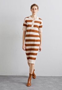 Rochie tricotată cu dungi alternative de culoare maro și crem, guler polo și mâneci scurte, având o siluetă de lungime medie și un material texturat.